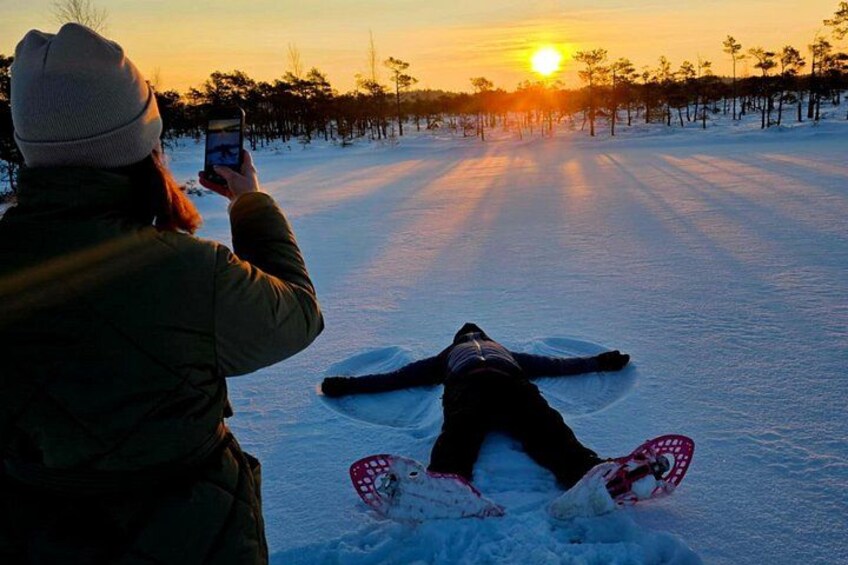 A person snowboarding on a snowy path with the sun setting in the background. 3