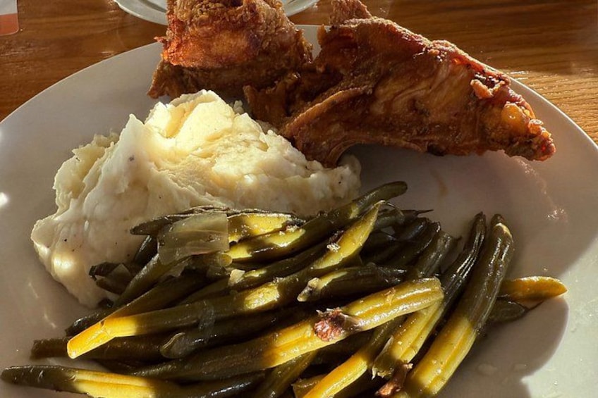 A plate with mashed potatoes, green beans, and fried chicken. 1