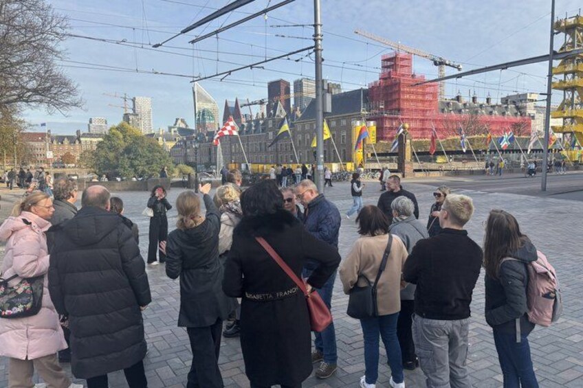 A group of people gathered in an urban square with tram tracks and buildings in the background. 5