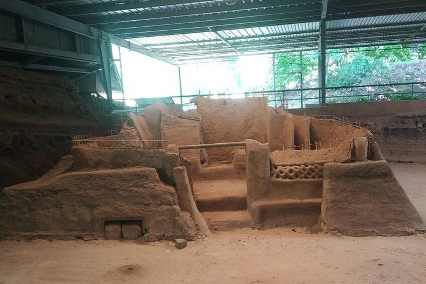 An ancient archaeological site with stone structures and a large open area. 5