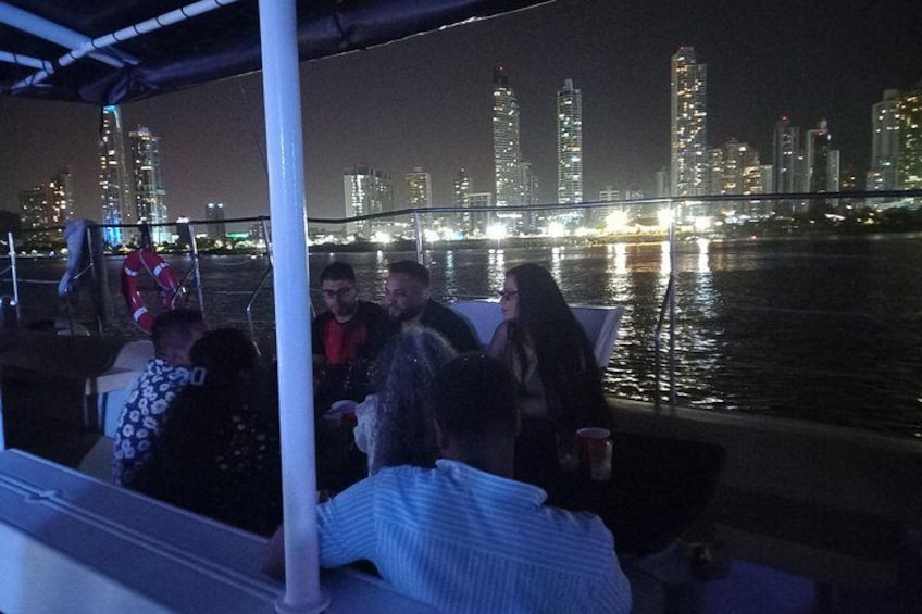 A group of people on a boat with a city skyline in the background. 2