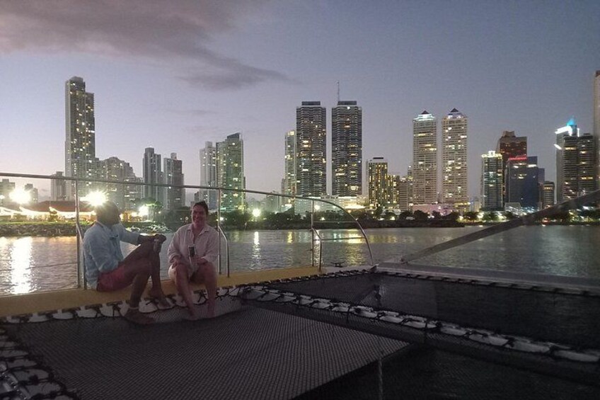 Two people sitting on a boat with a city skyline in the background. 3