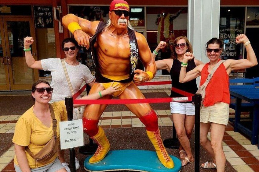 Une statue représentant un lutteur, avec des personnes posant autour. 4