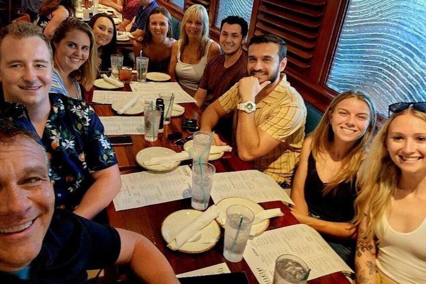 Un groupe de personnes est assis à une table de restaurant, devant des menus et des verres. 3