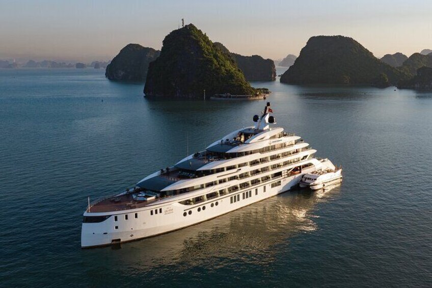 A large white cruise ship docked near a group of green islands in a calm sea. 1