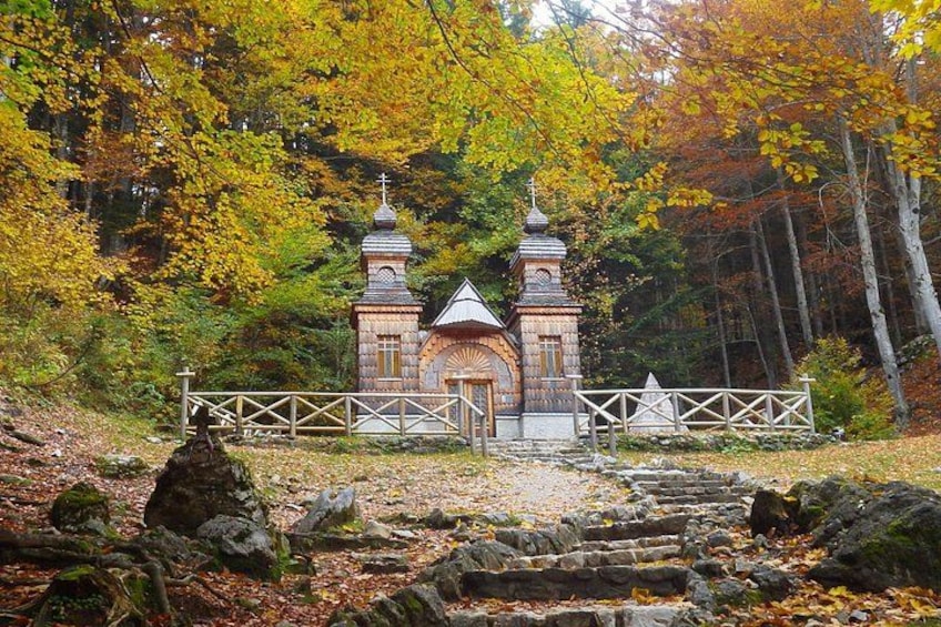 A small wooden chapel surrounded by autumn foliage. 2