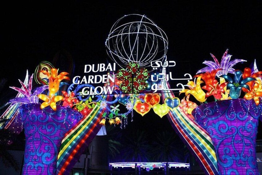 A brightly lit entrance with a globe and floral decorations, labeled 'DUBAI GARDEN GLOW'. 2