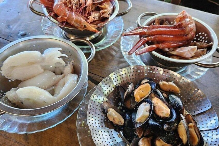 A table with seafood including shrimp, mussels, and squid. 3