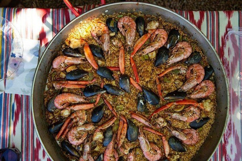 A large pan filled with seafood, including shrimp and mussels, on a striped tablecloth. 5