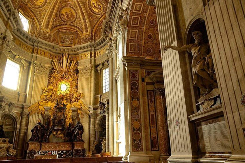 An ornate interior with a central golden statue, columns, and detailed ceiling artwork. 2