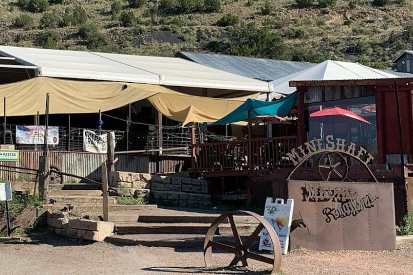 Un espace de restauration extérieur rustique, agrémenté d’une enseigne en bois sur laquelle on peut lire « MINESHART ». 3