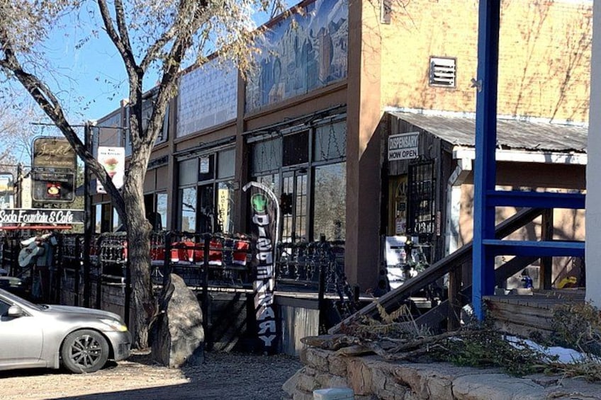 Une scène de rue avec un immeuble, un arbre, une voiture et une enseigne indiquant « Scott Fountain Cafe ». 2