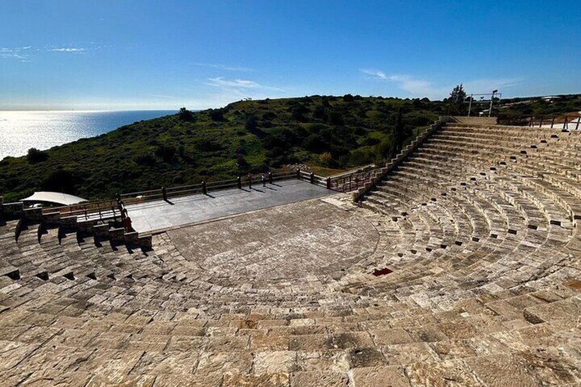 Un amphithéâtre antique avec des gradins en pierre et une vue sur la mer. 5