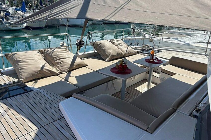 Een jachtdek met lounge stoelen, een tafel en uitzicht op de jachthaven. 1