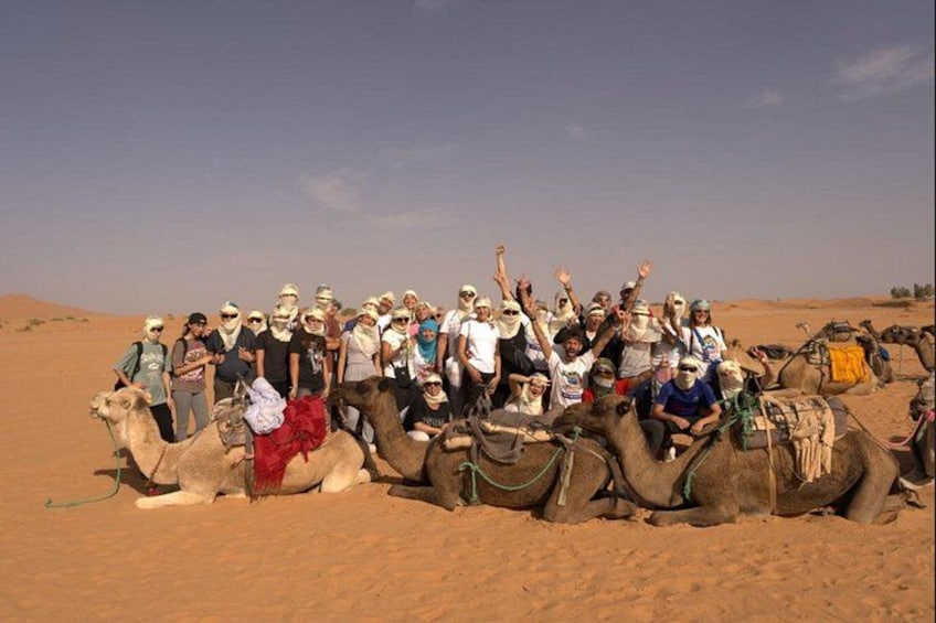 A group of people on camels in a desert. 4