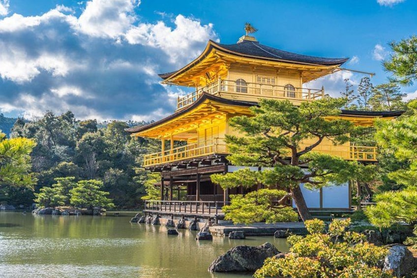 A traditional Japanese building with a golden roof, surrounded by water and greenery. 5