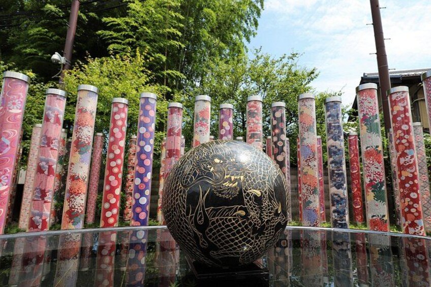 A decorative glass sphere with intricate patterns, surrounded by a fence with colorful, patterned posts. 3