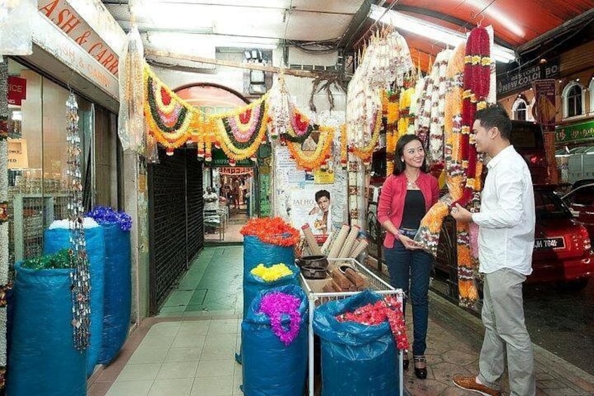 A street market with stalls decorated with colorful garlands and flowers. 4