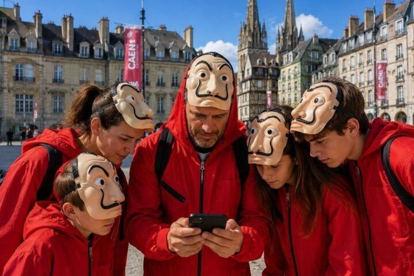 A group of people in red jackets with masks, standing in a public square with historic buildings in the background. 1