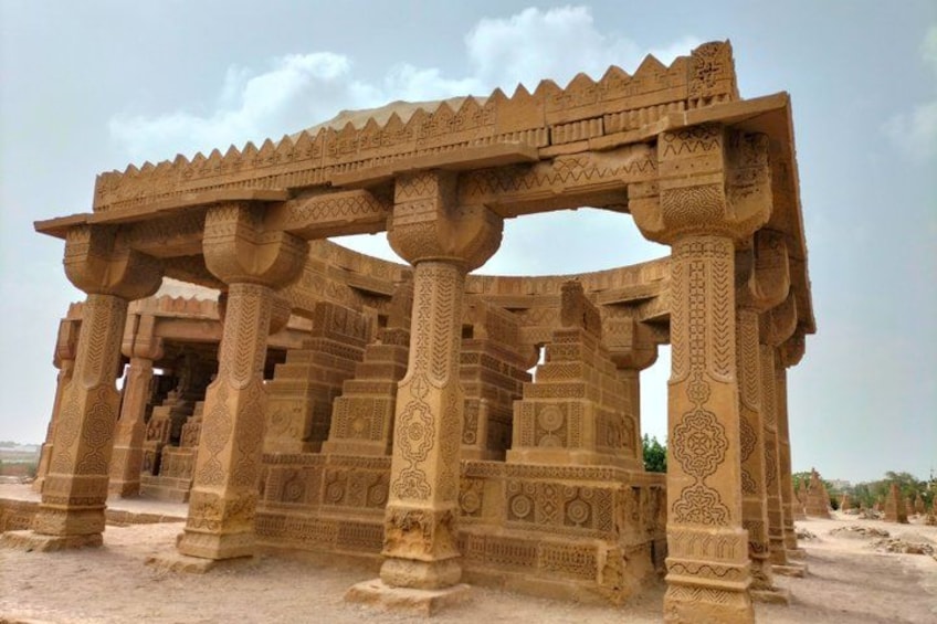 A large, intricately carved stone structure with multiple columns and a detailed roof design. 2