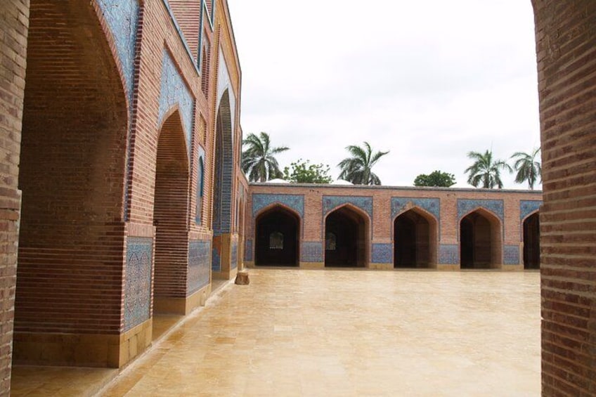 A courtyard with brick arches and a tiled floor. 4