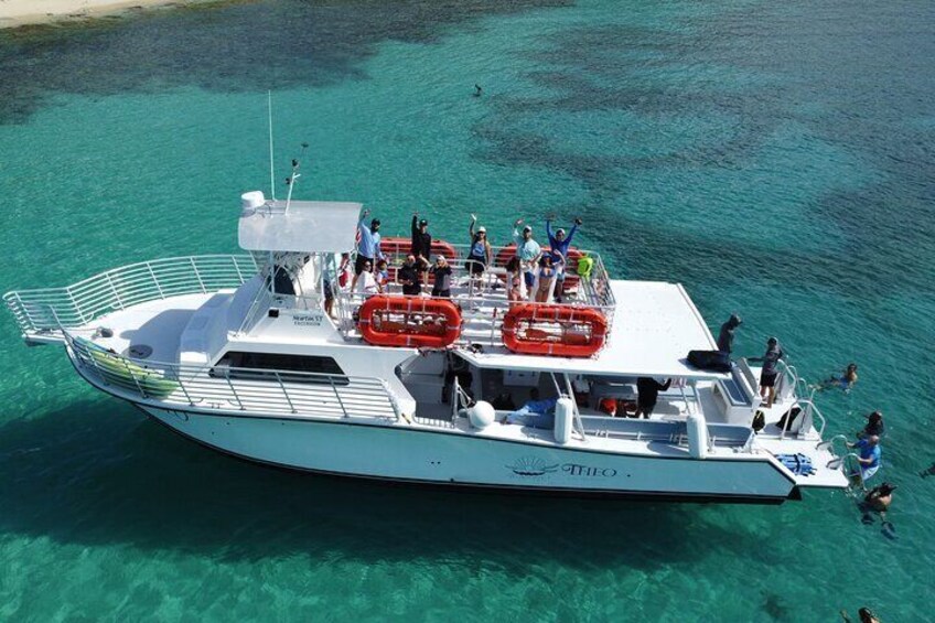 Un bote con gente a bordo, rodeado de agua turquesa cristalina. 3