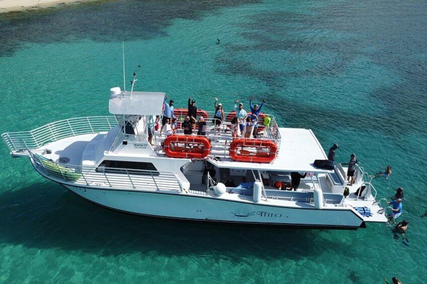 Un bateau avec des personnes à bord, entouré d’une eau turquoise et cristalline. 5