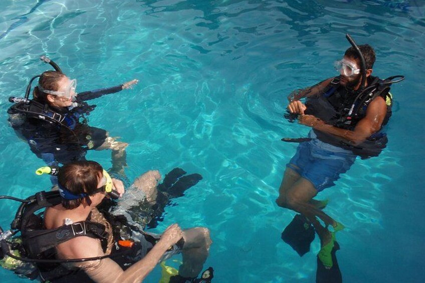Trois personnes font de la plongée sous-marine dans une piscine. 2