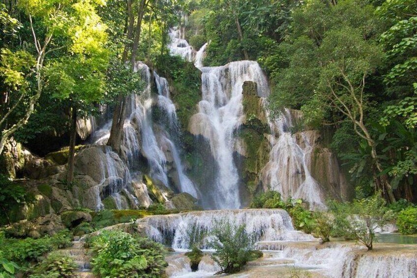 A multi-tiered waterfall surrounded by lush greenery. 1