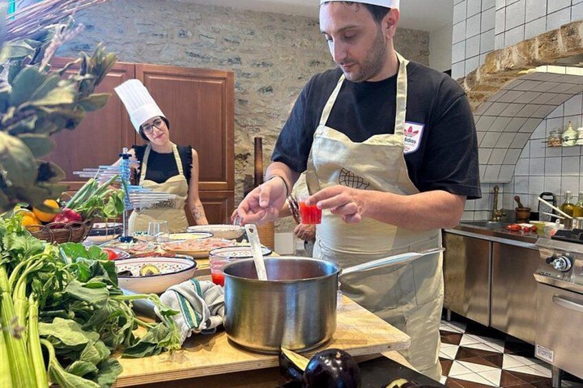 A chef preparing food in a kitchen with a tiled backsplash and various cooking utensils. 3