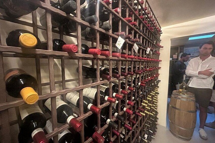 A wine cellar with rows of wine bottles on wooden racks. 5