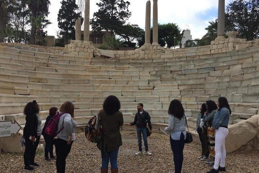 A group of people standing in front of ancient stone steps and columns. 4