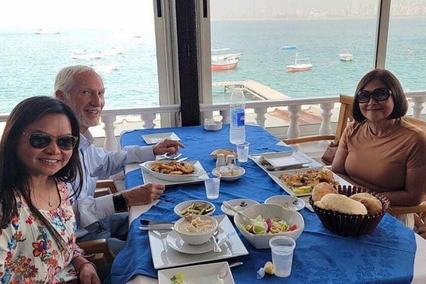 A table with food, a view of the sea, and boats in the background. 4