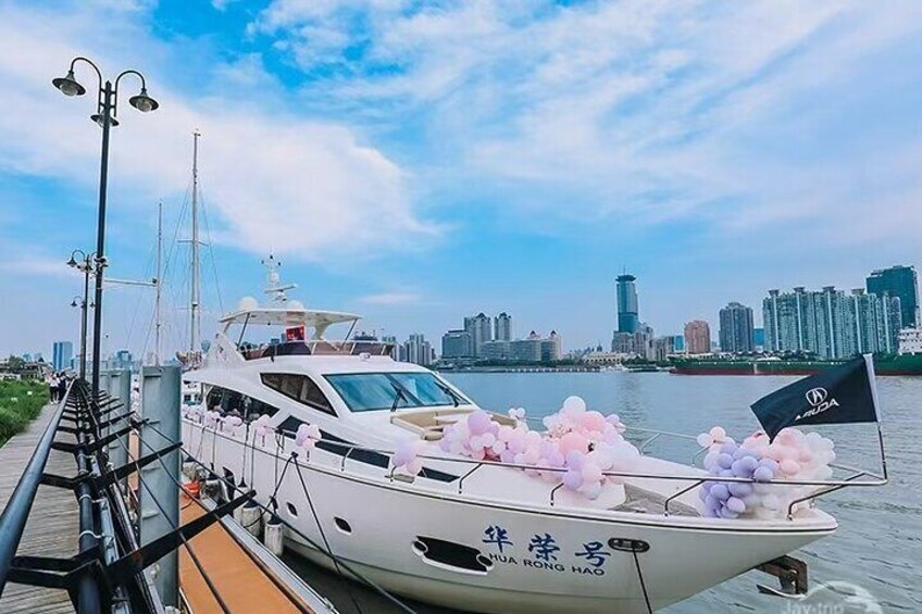 Un yate blanco amarrado en un muelle, con un horizonte urbano de fondo. 4