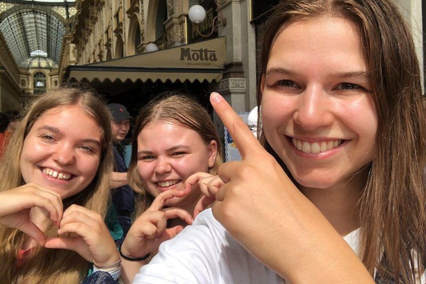 A group of people in front of a building with a sign that reads 'Motta.' 3