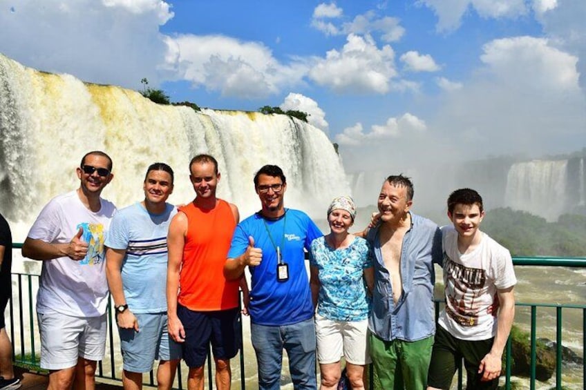 A group of people standing in front of a waterfall. 1