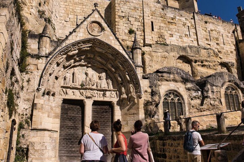 A historic stone building with a pointed arch entrance and detailed carvings. 2