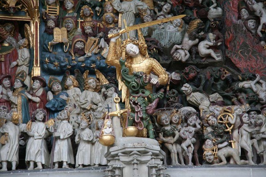 A detailed sculpture of a religious scene with a central figure holding a cross, surrounded by various other figures and objects. 2