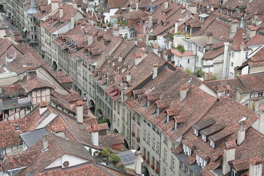 Une zone urbaine densément peuplée, caractérisée par des immeubles à étages construits très près les uns des autres, des rues étroites et des toits recouverts de tuiles rouges. 5