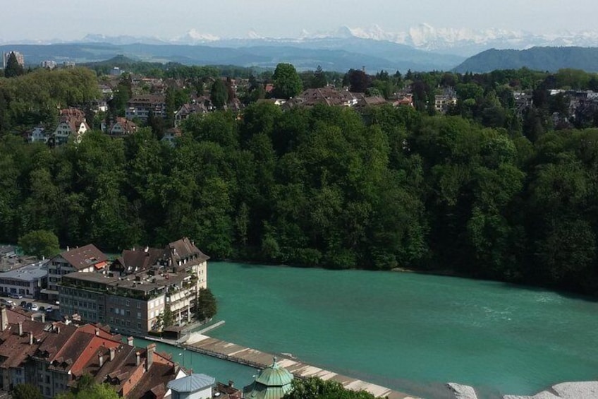 Une rivière traversée par un pont, une ville avec des bâtiments et des montagnes en arrière-plan. 3