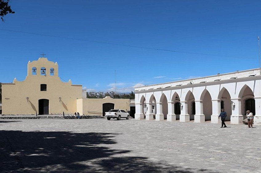 A building with a bell tower and arched walkways. 2