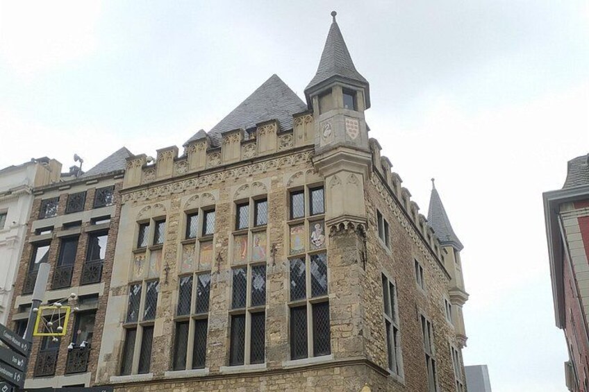 A historic building with ornate stonework, multiple windows, and a pointed roof. 2