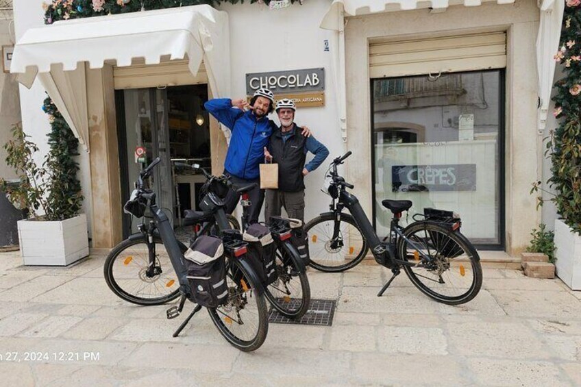 To personer står foran en butik kaldet 'Chocolab', med cykler parkeret foran. 1