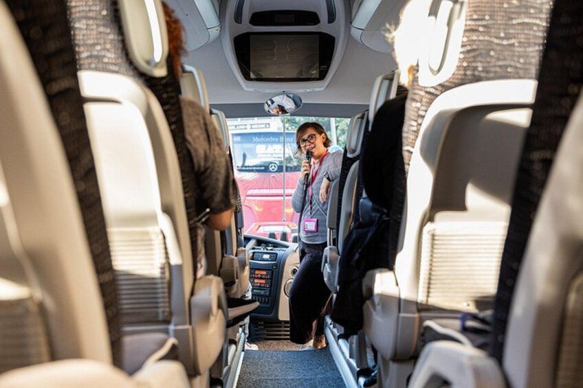 A bus interior with passengers seated and a driver at the front. 5