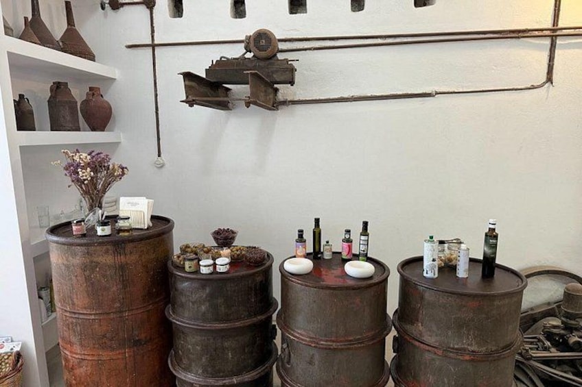 Un intérieur rustique agrémenté de barils en bois, d’étagères où sont exposées des poteries et d’un ventilateur d’époque. 5