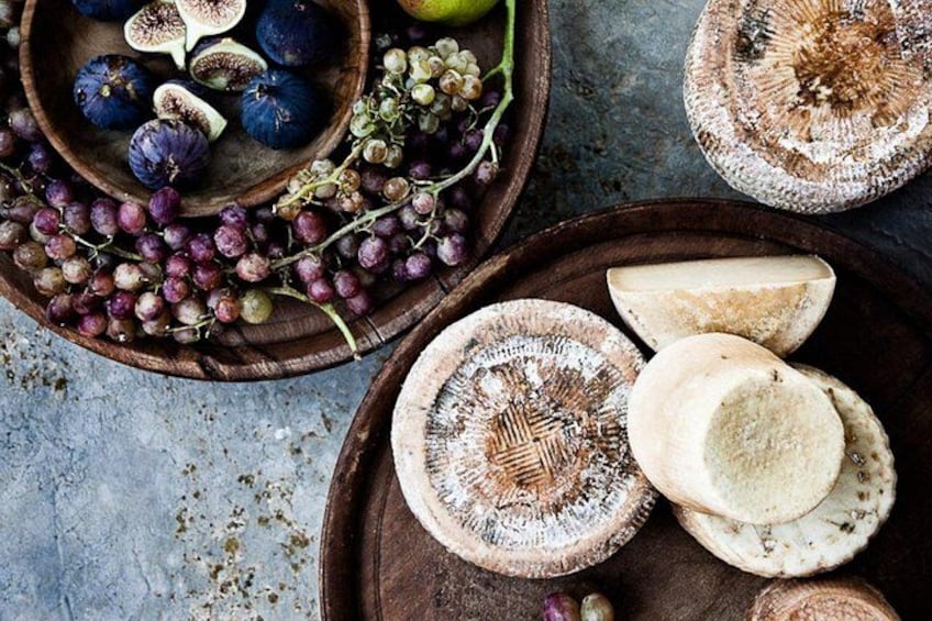 Une planche en bois garnie de champignons en tranches, de raisins et de figues. 1