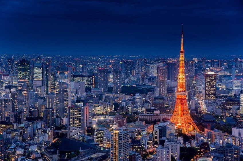 A cityscape at night with the illuminated Tokyo Tower and numerous high-rise buildings. 1