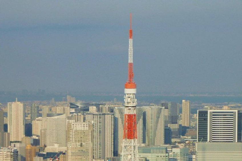 A cityscape with a prominent tower featuring a red and white color scheme, surrounded by various buildings and skyscrapers. 3