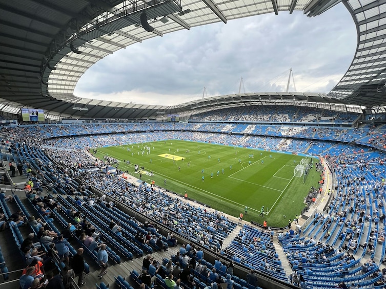 A large stadium with blue seats and a green field. 4