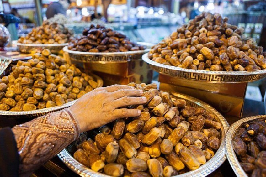 Une grande variété de fruits secs et de noix présentés dans de grands bols sur un marché. 4